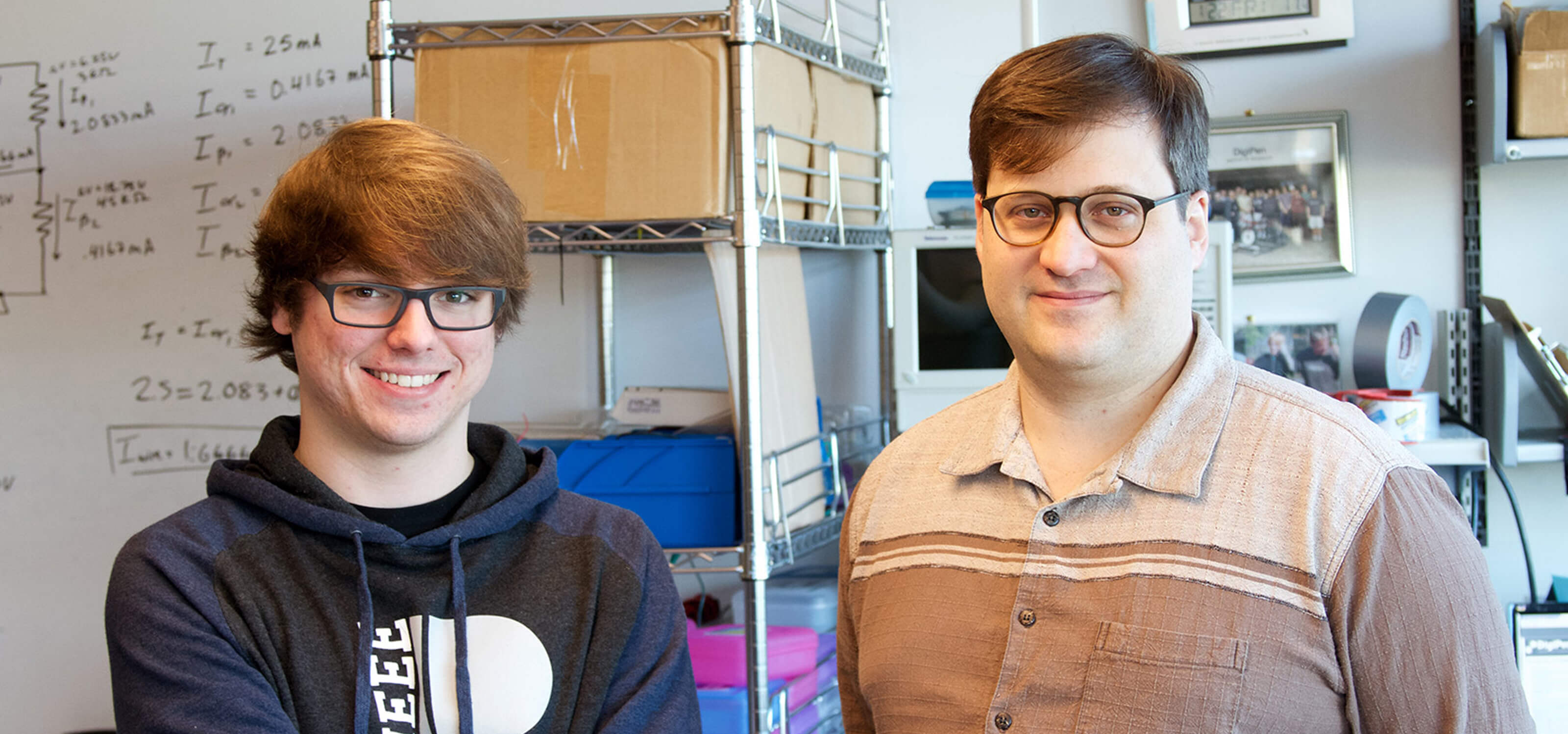 DigiPen student Jimi Huard and professor Jeremy Thomas smiling side by side in a DigiPen computer engineering lab