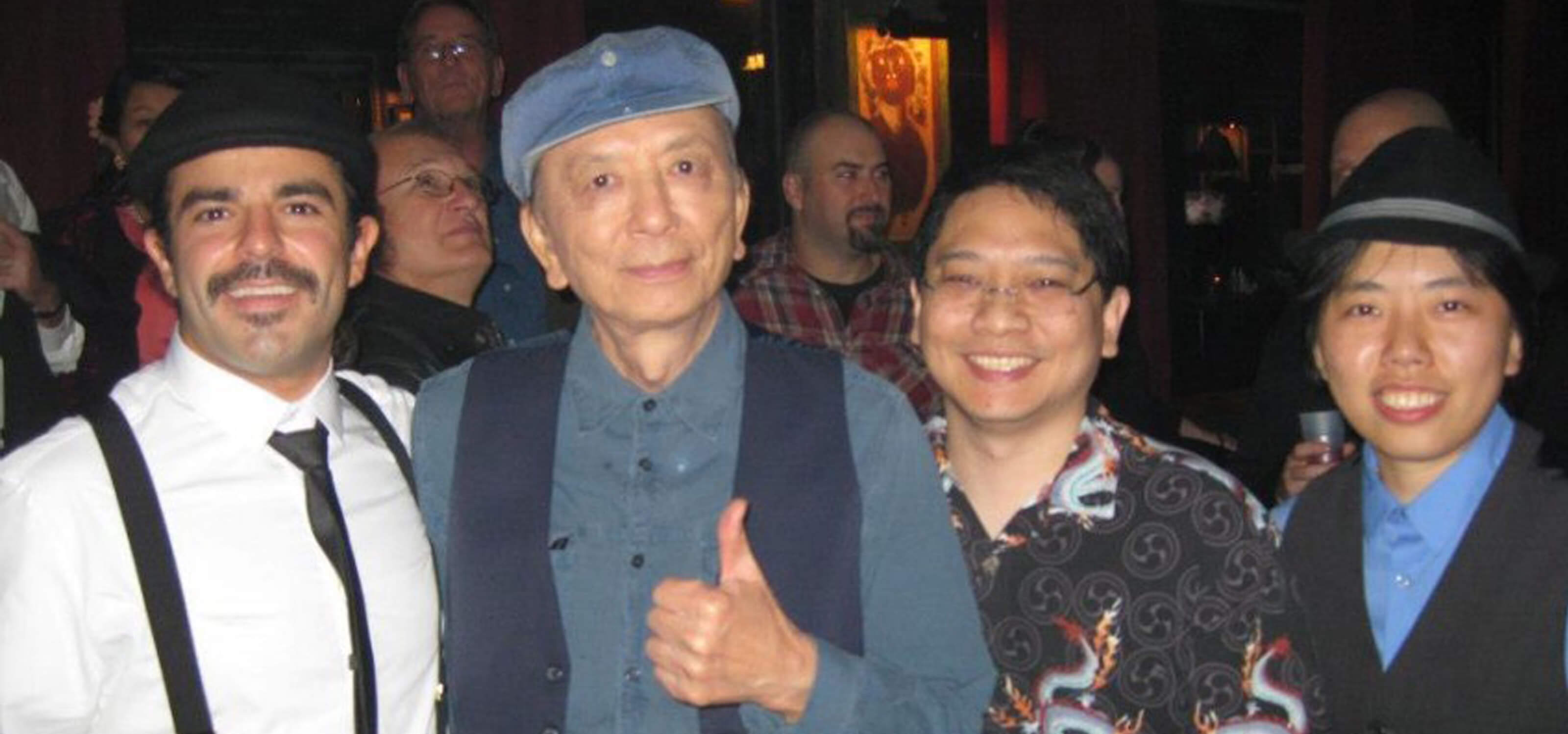 Photo of DigiPen alumna Joanna Leung and two of her colleagues with Call of Duty voice actor James Hong at a launch party 