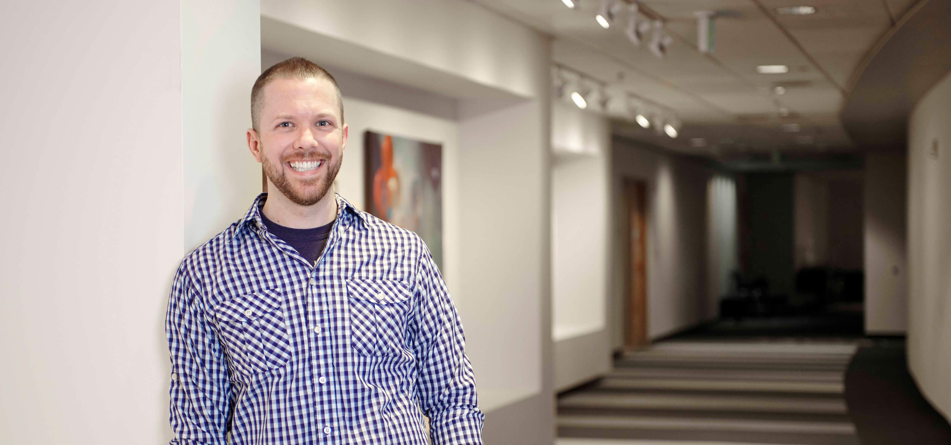 Game Software Design and Production Senior Lecturer Justin Chambers smiles in a DigiPen hallway.