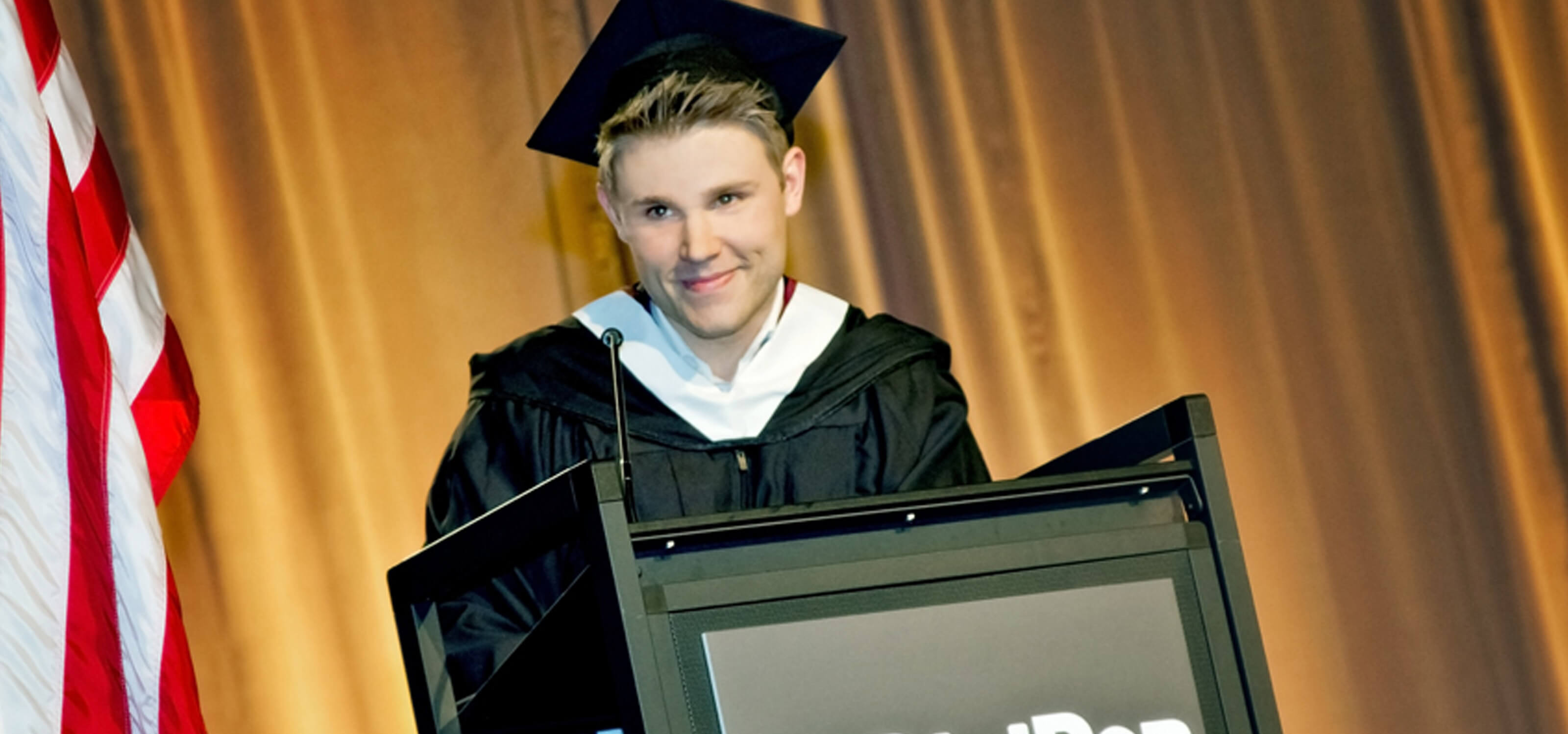 DigiPen graduate Kevin French speaking at the podium at the 2013 commencement ceremony