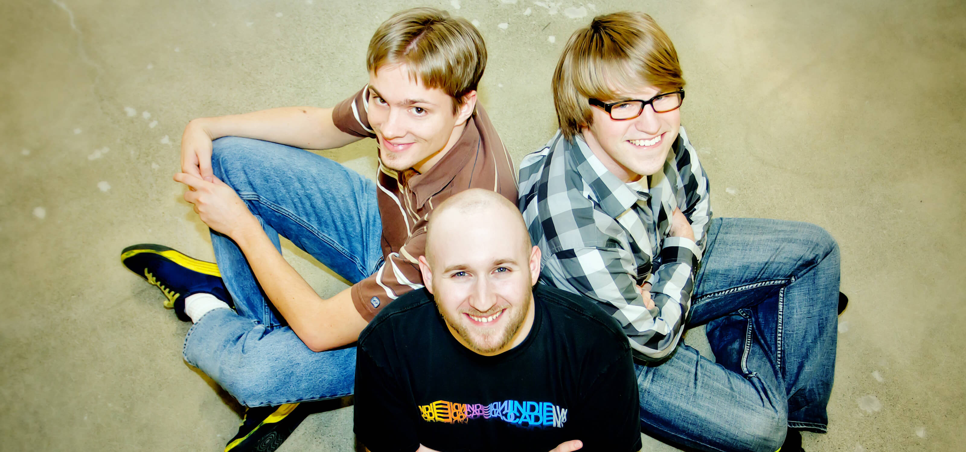 Top-down view of DigiPen alumni Kyle Holdwick, Jordan Hemenway and Jason Nollan sitting in a circle