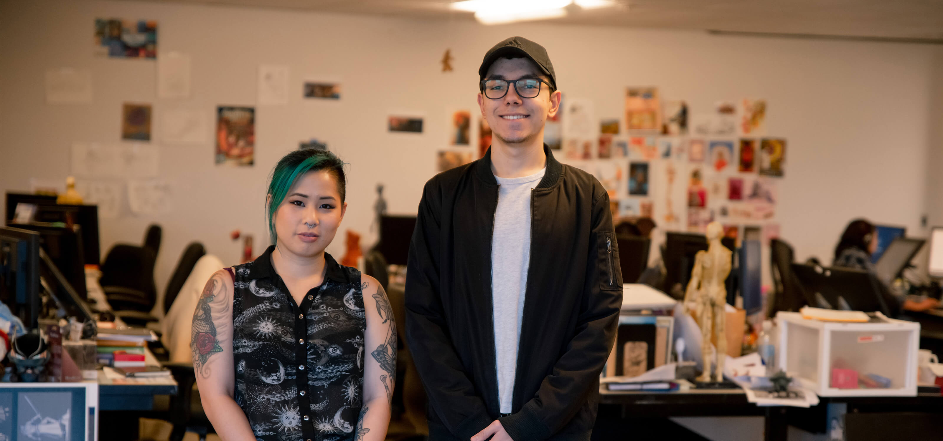 Trang “Sushie” Ta and Jesse Munguia stand next to each other in the DigiPen MFA lab.
