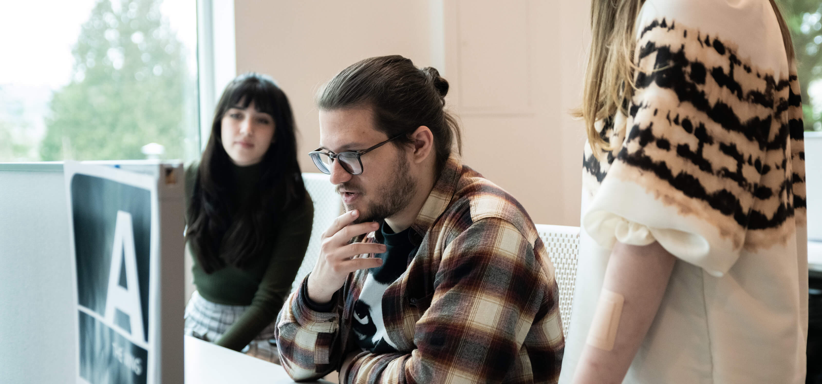 Mike Doeren looks at his laptop in DigiPen’s campus lab, surrounded by two other students.