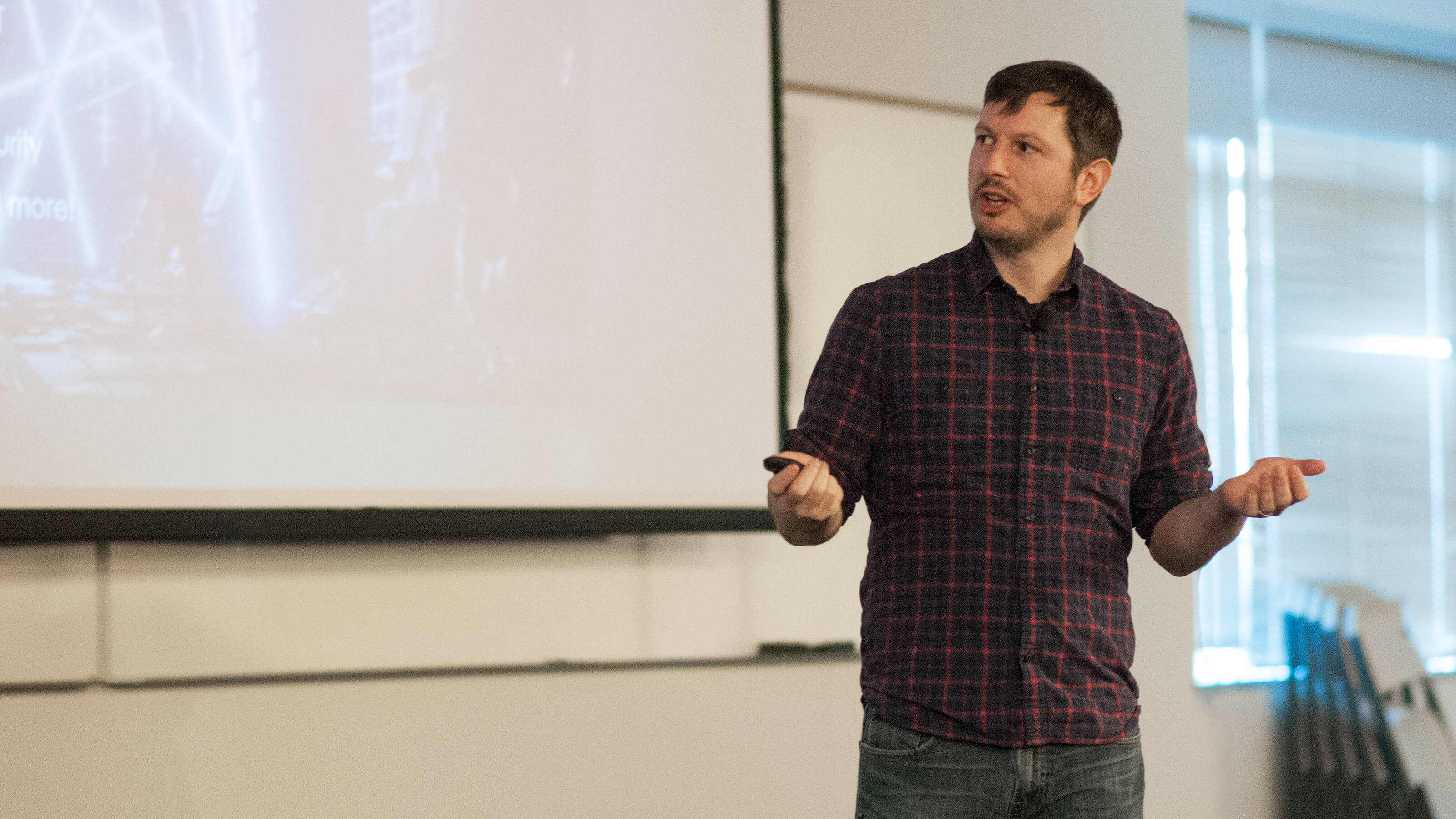 DigiPen alumnus Peter Kugler speaking in front of a projection screen at the Bungie Career Talk