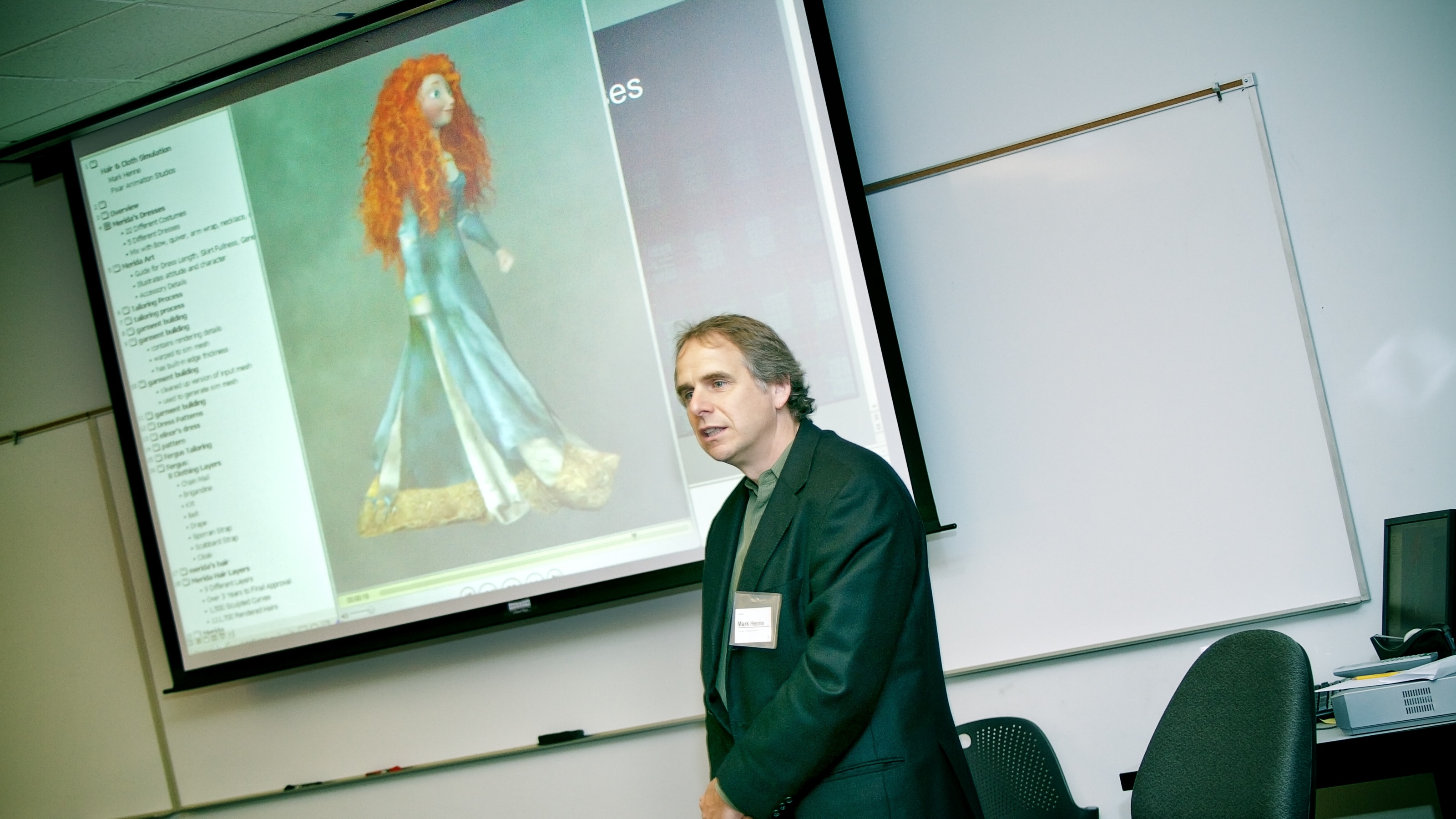 Pixar's Mark Henne speaking in front of a screen showing Princess Merida from the animated movie Brave