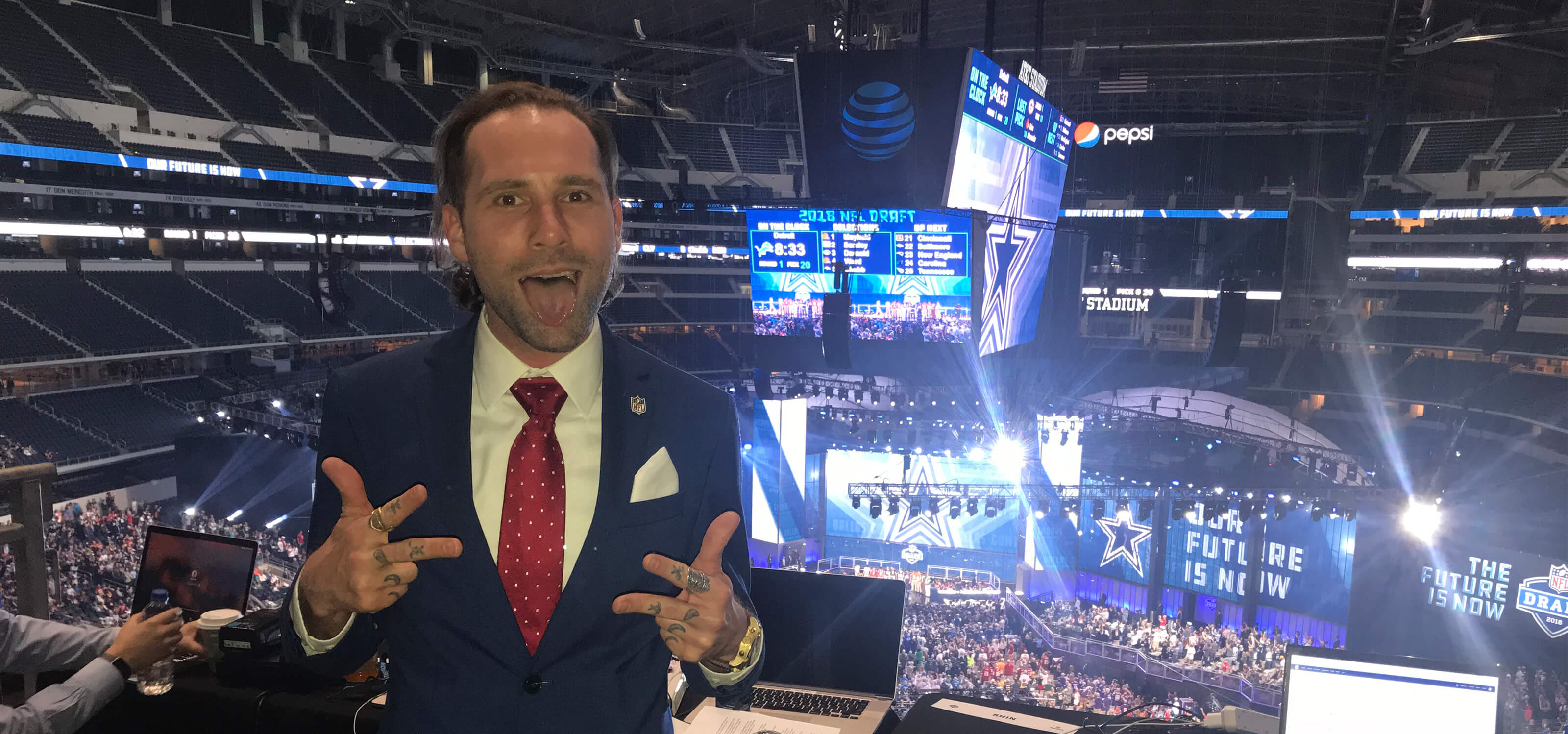 Ryan Dudley poses for the camera above the crowd at the NFL draft.