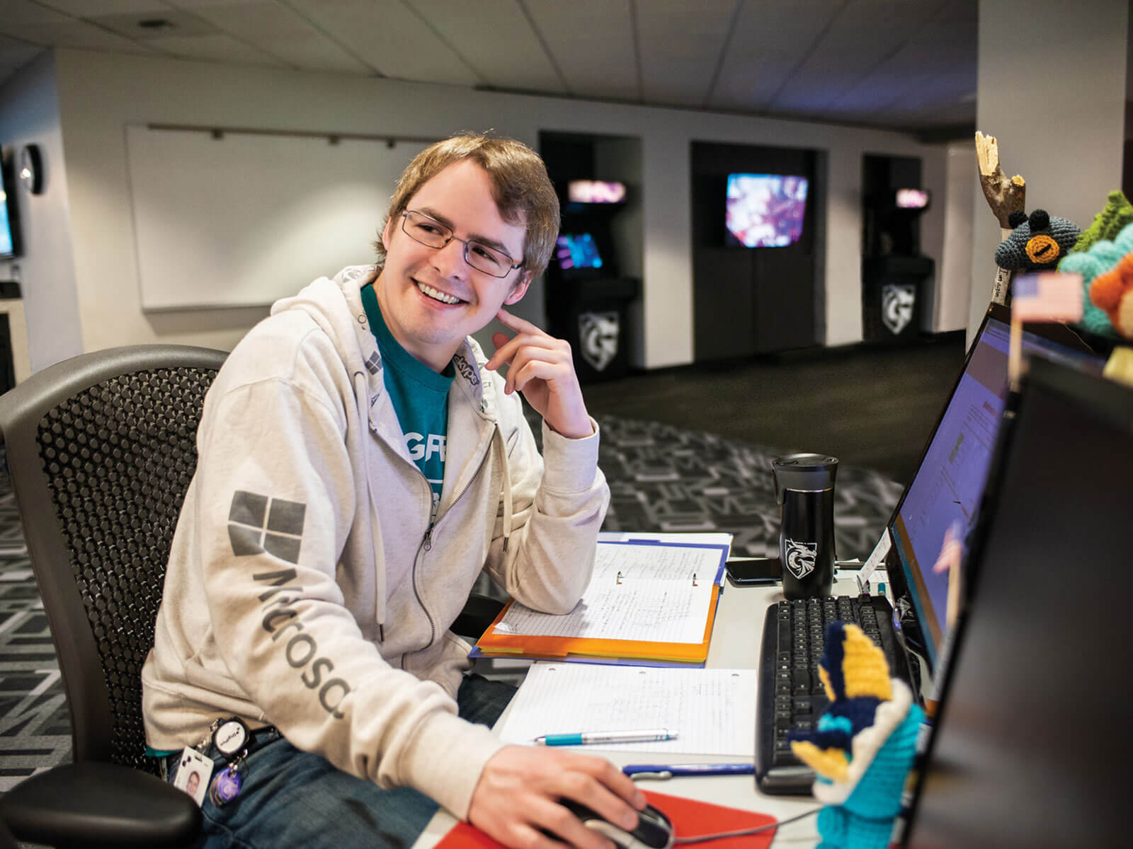 Computer science student sits at desk inside computer lab