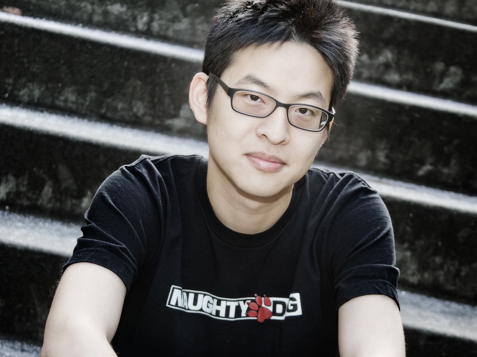 DigiPen RTIS alumnus Allen Chou sitting on stairs on the DigiPen campus