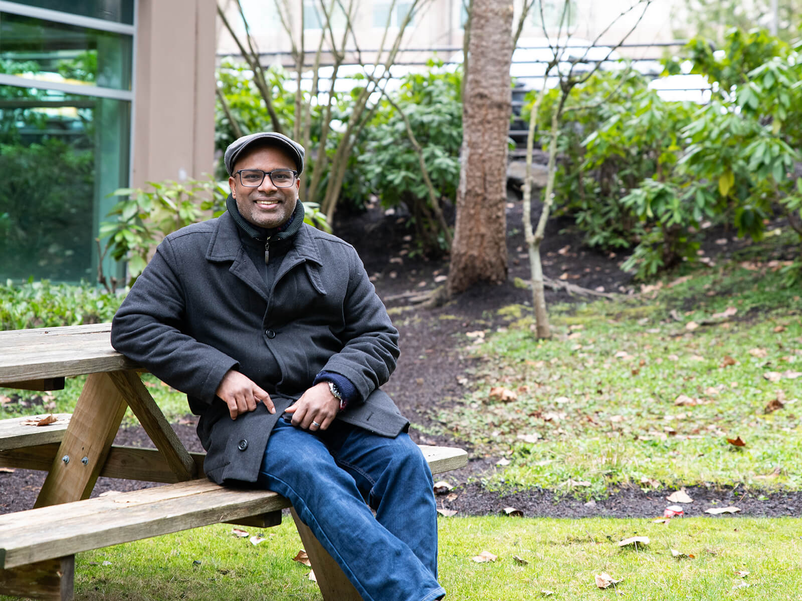 Anand Thirumalai sits at an outdoor picnic table.