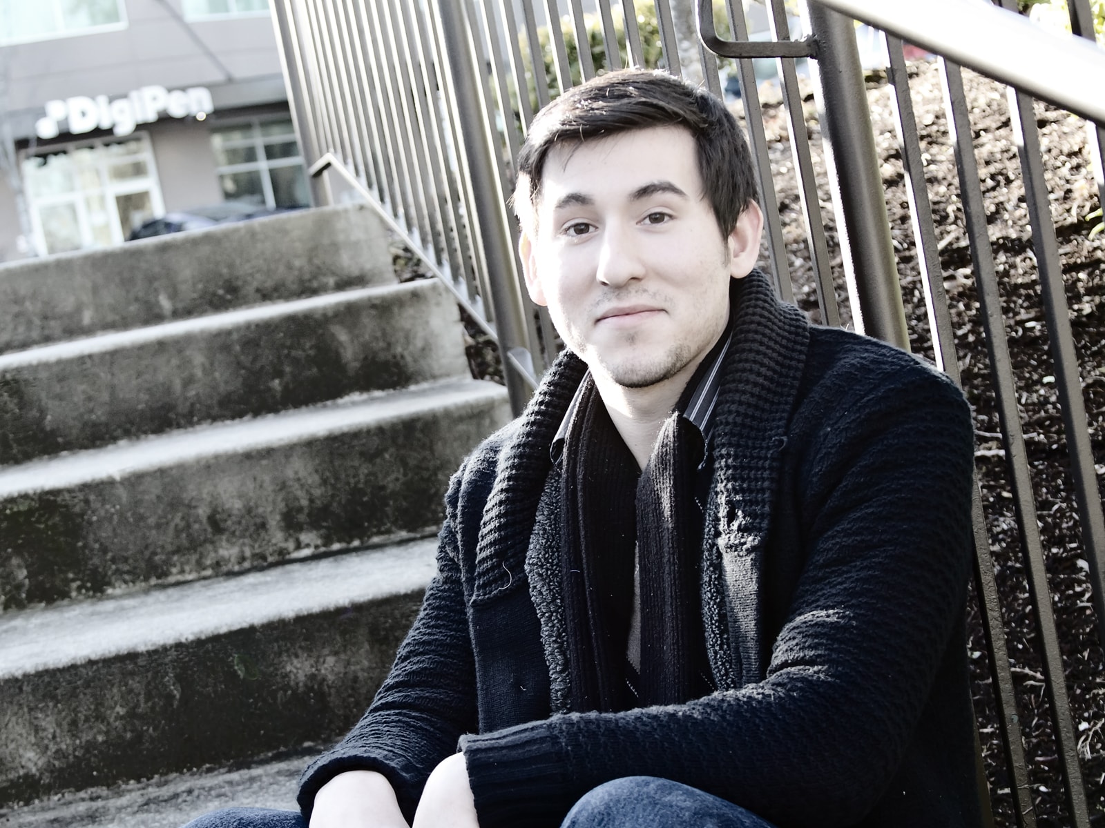 DigiPen student Andrew Alvarez posing on stairs outside the DigiPen building