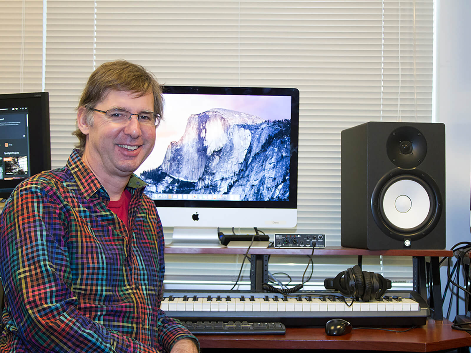 DigiPen music senior lecturer Brian Schmidt sits in front of a computer in the DigiPen sound lab