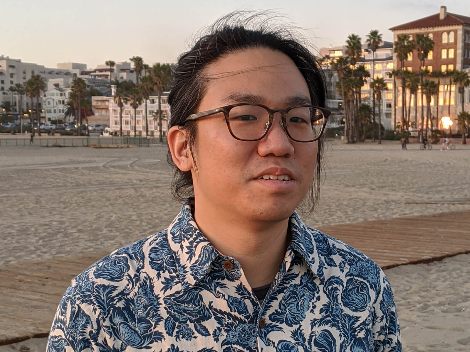 DigiPen graduate Chia-Hao Ching poses on a beach lined with palm trees. 