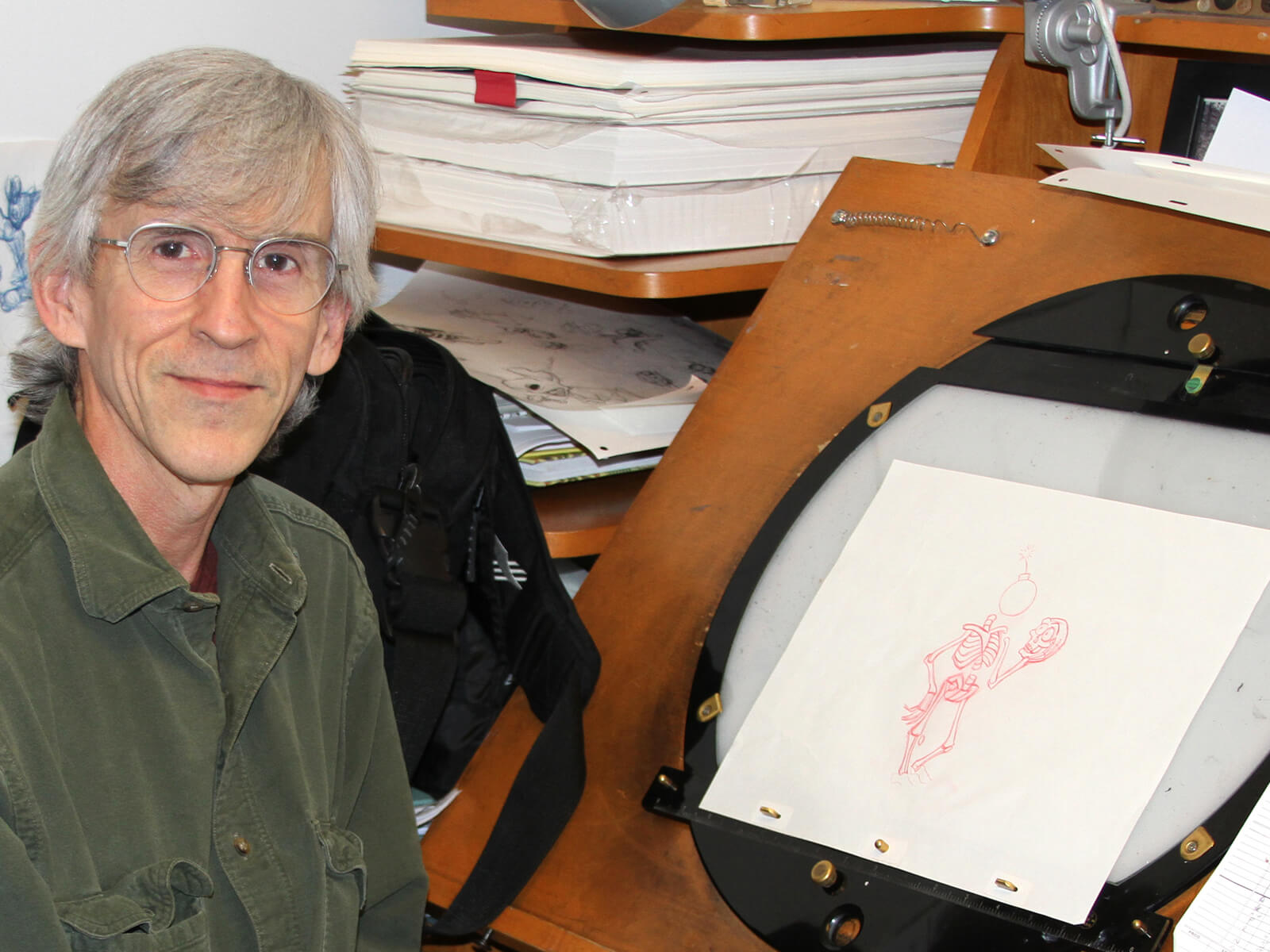 DigiPen animation professor Dan Daly sits at his desk with an original rough in-between drawing from the Aladdin game.