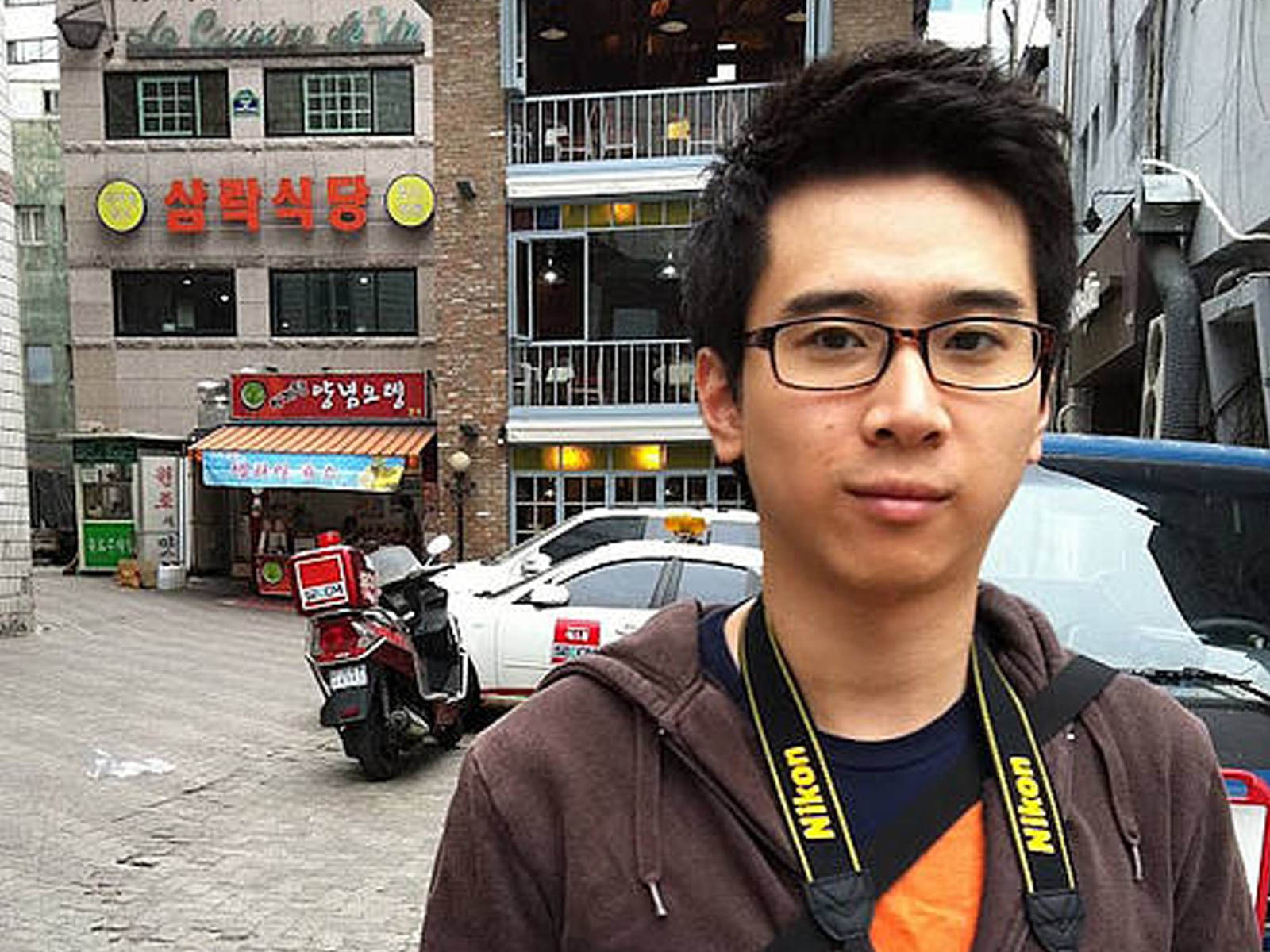 DigiPen alumnus David Ly posing in front of a Korean storefront