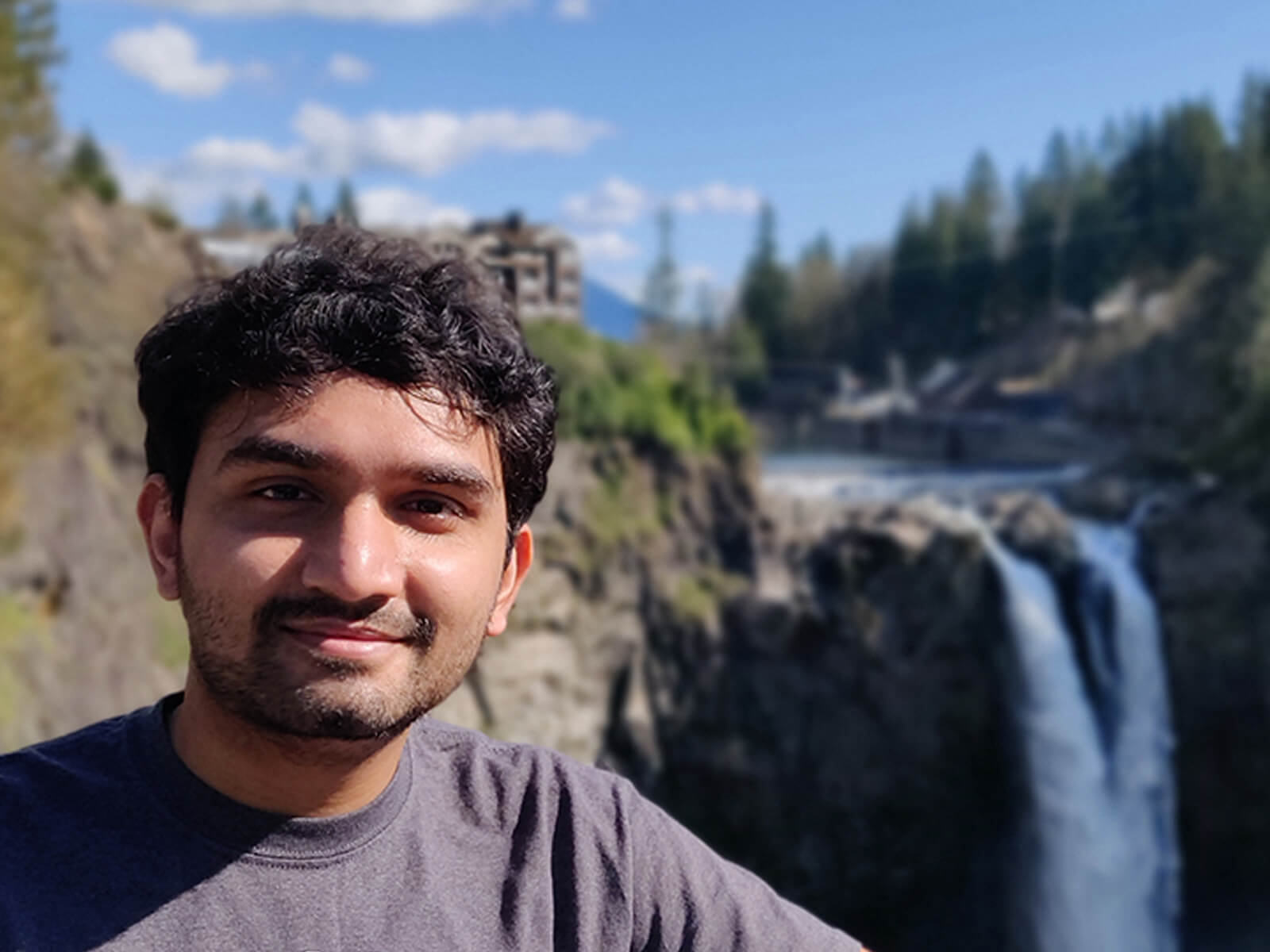 DigiPen MS in Computer Science graduate Dhrumil Shukla poses in front of Snoqualmie Falls