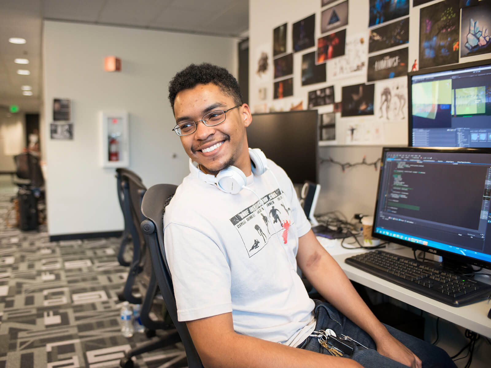 A DigiPen student smiling as he leans away from a computer screen
