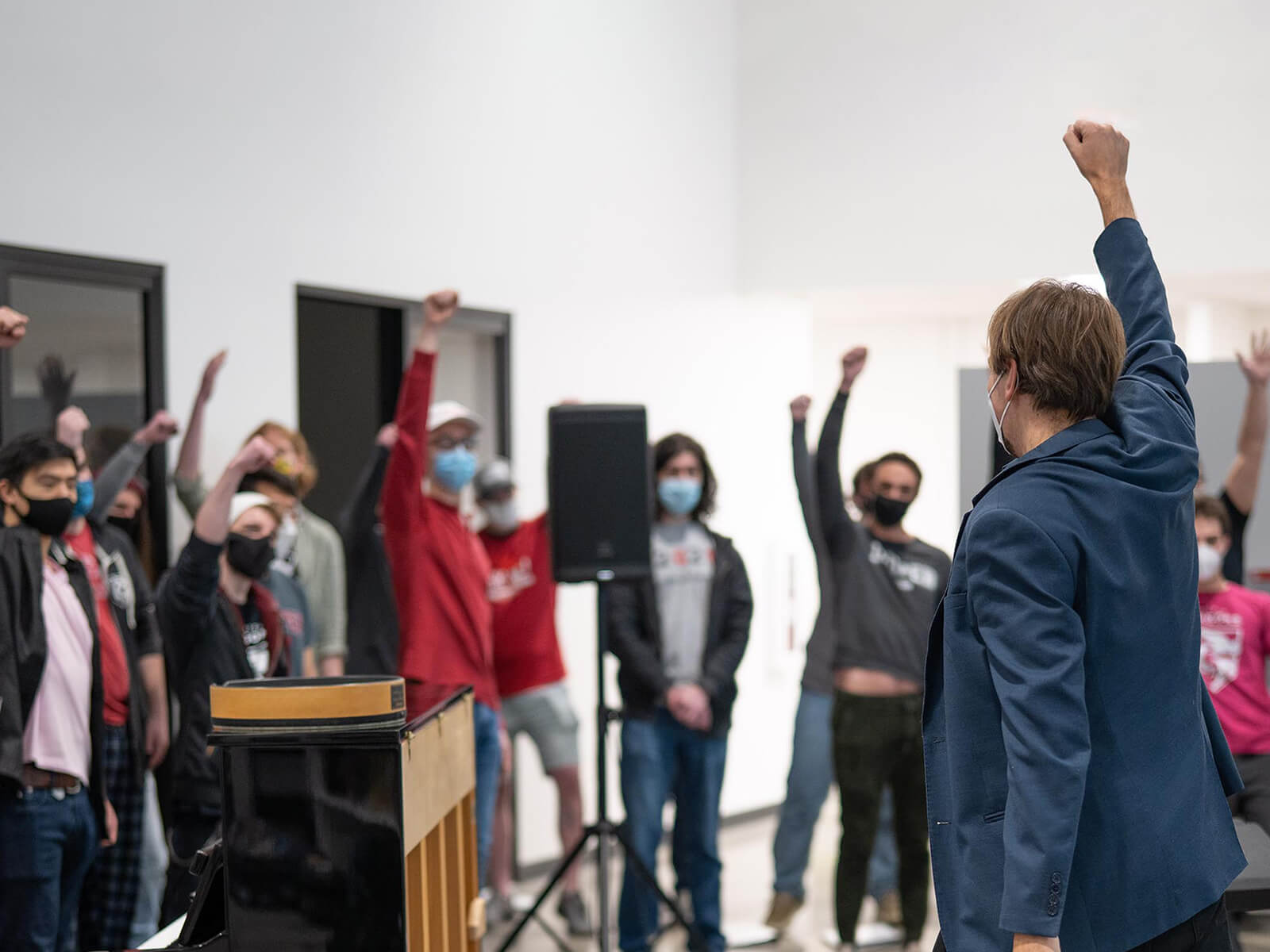 The DigiPen Dragon Chorus raises their fists in celebration in The Wing.