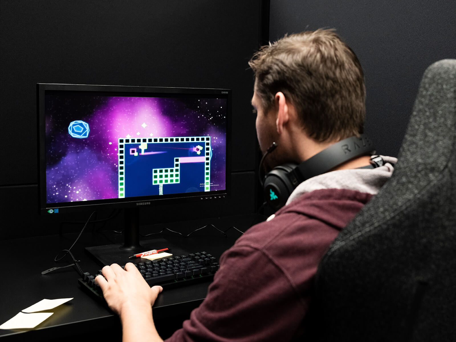 A DigiPen student plays a PC game in a Nightingale lab testing bay.