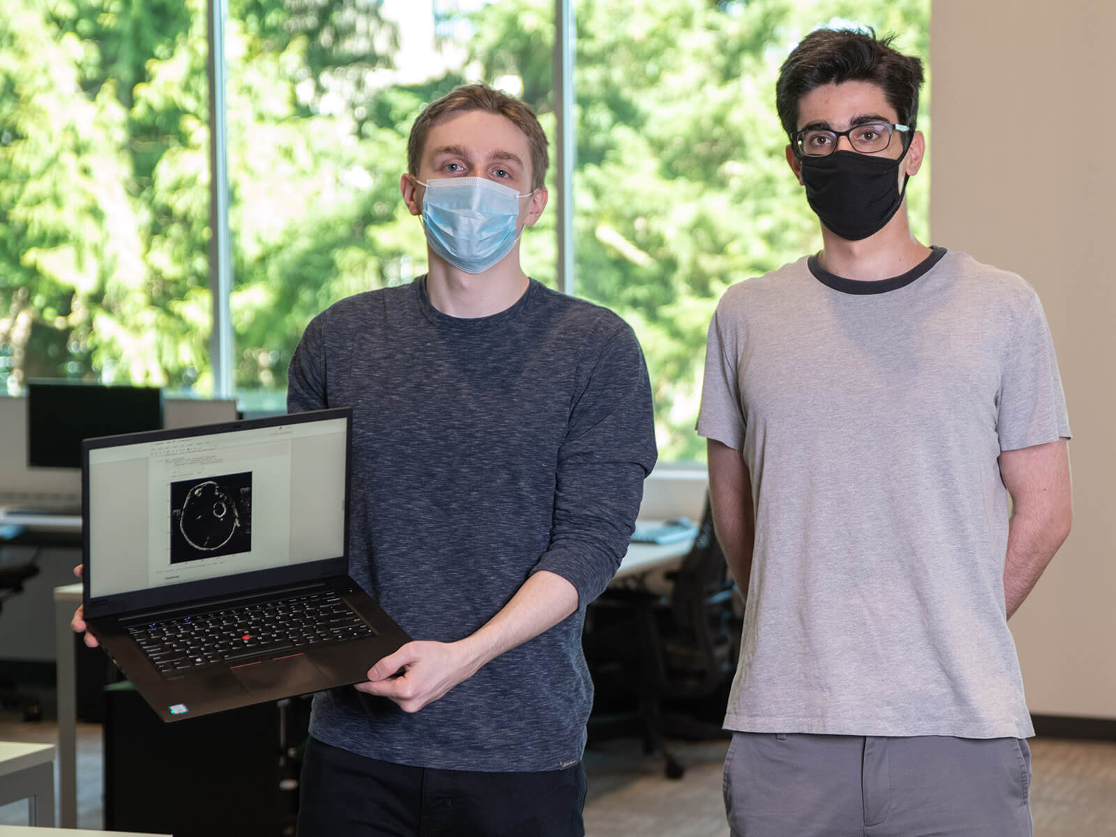 DigiPen BS in Computer Science in Machine Learning sophomores Eric Zander and Andrew Ardeleanu pose in a campus computer lab wearing face masks. 