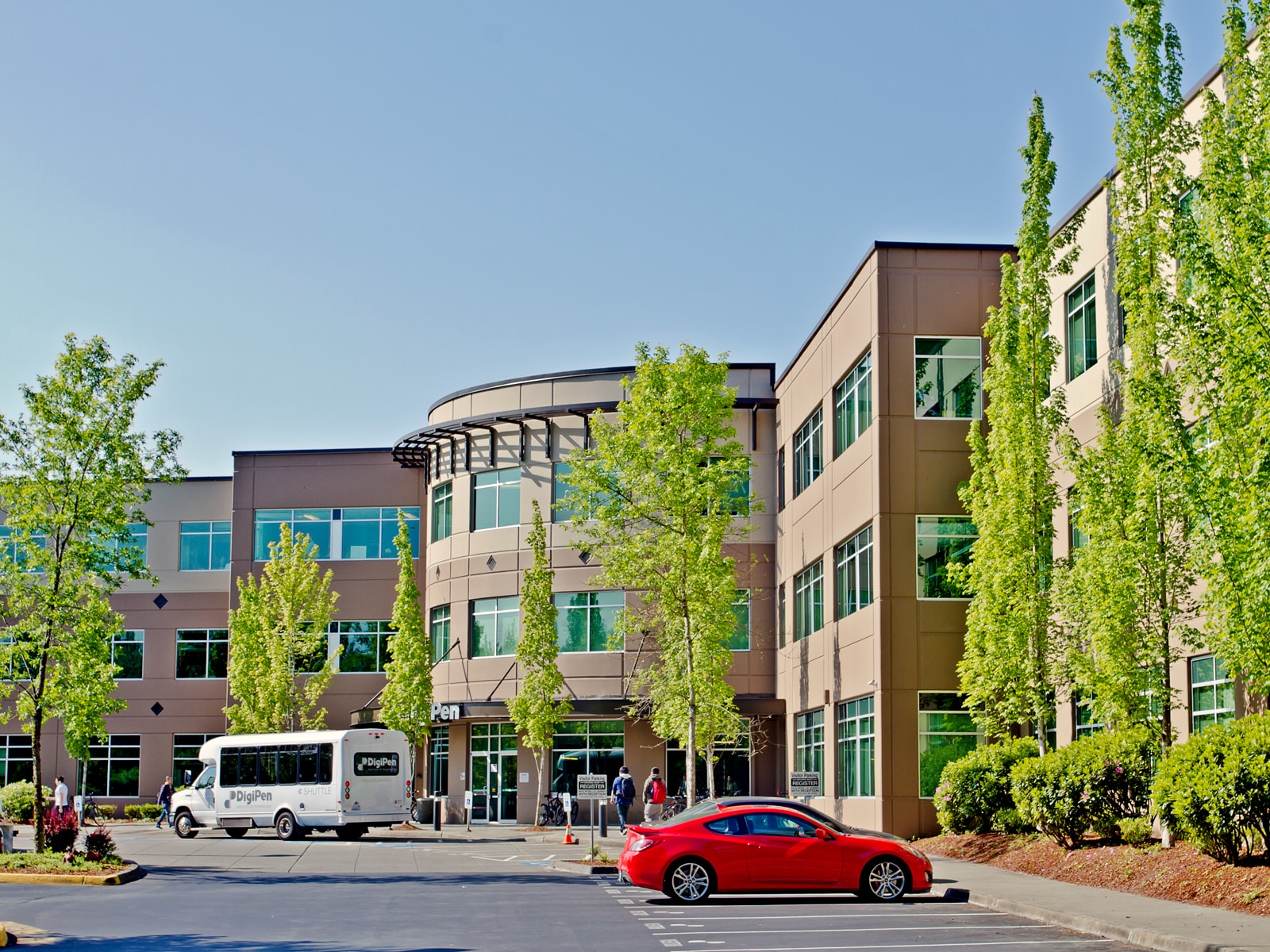 Picture of the DigiPen front entrance with the DigiPen shuttle bus on a sunny day