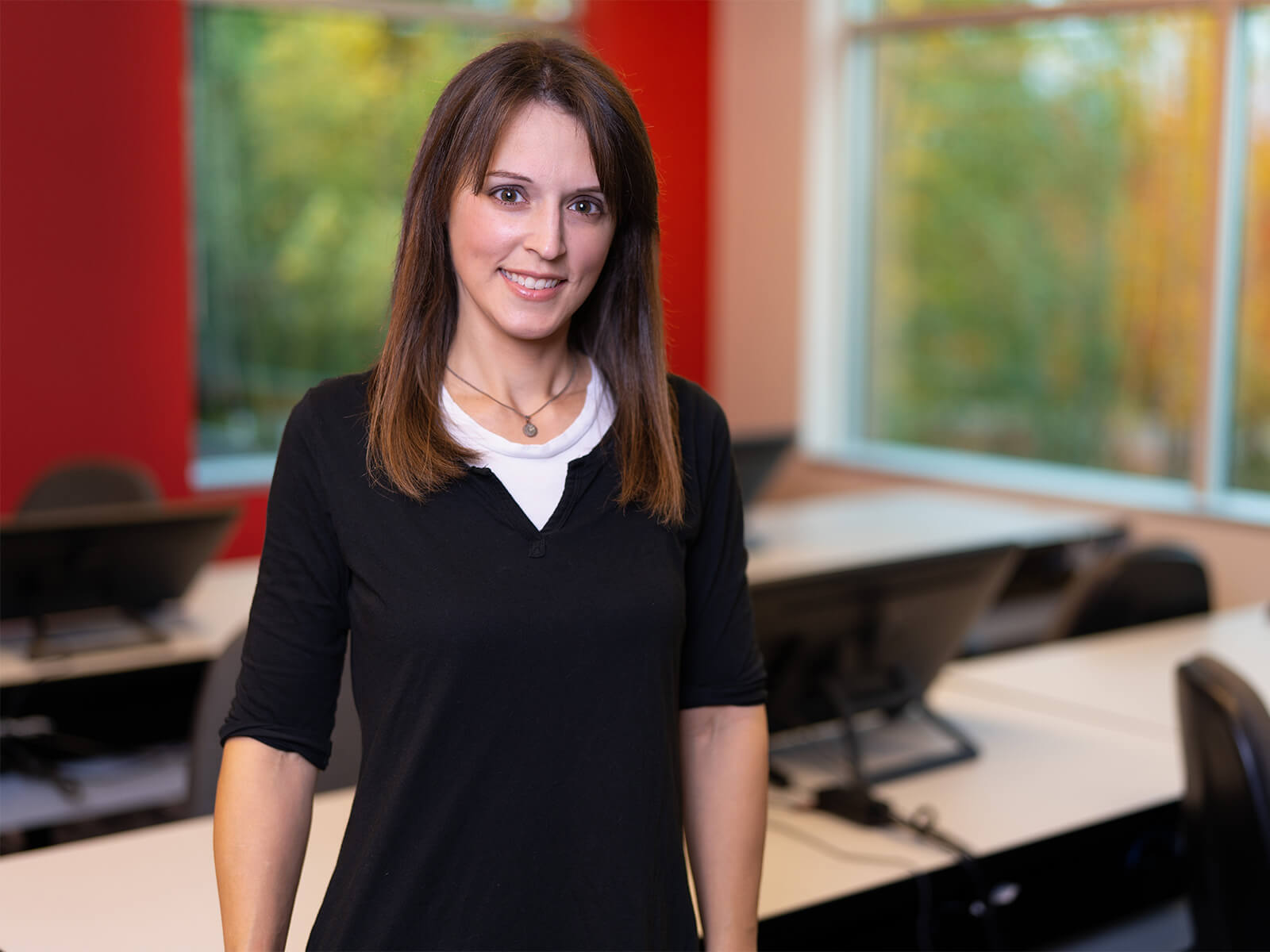 Professor Vanessa Hemovich poses for the camera in a DigiPen classroom..