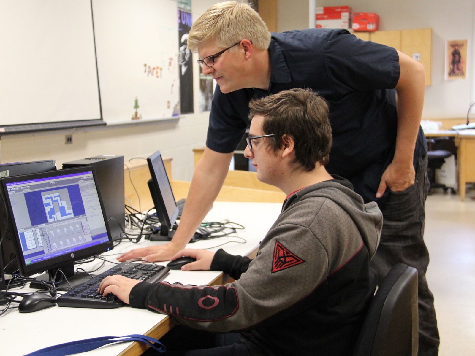 Student and teacher looking at a computer monitor in a Kamloops, British Columbia classroom