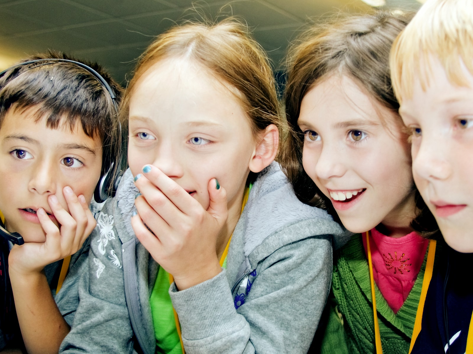Four young ProjectFun students smiling at a computer monitor