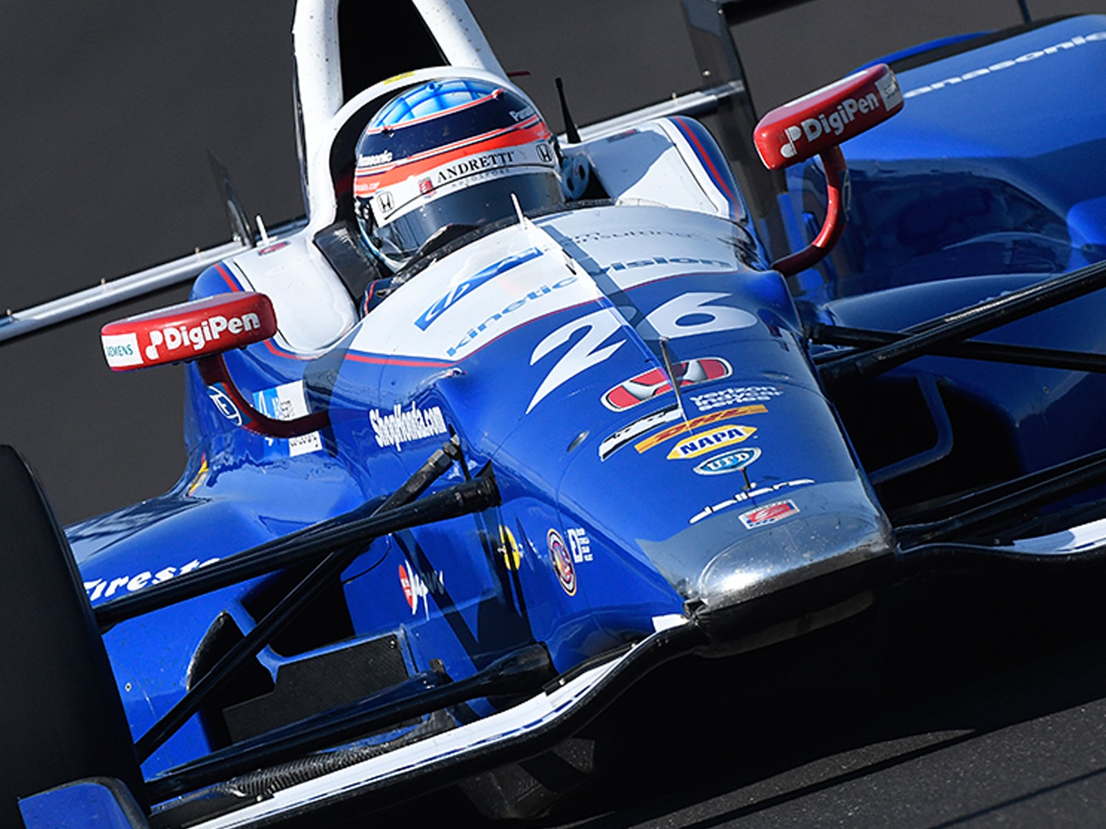 Takumo Sato driving an Indy car featuring the DigiPen logo