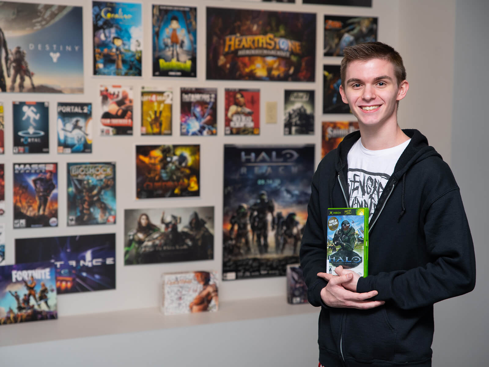 Brandon Stam poses on DigiPen’s campus with a copy of the original Halo game.