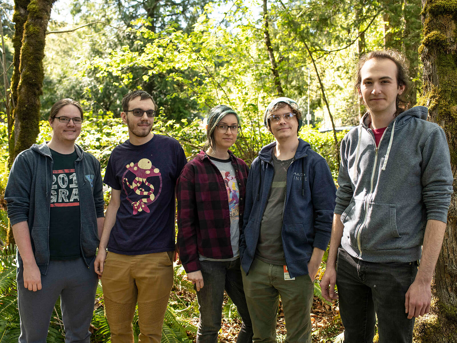 Student game team Free Minds poses in front of the Redmond forests that inspired The Pilgrim.