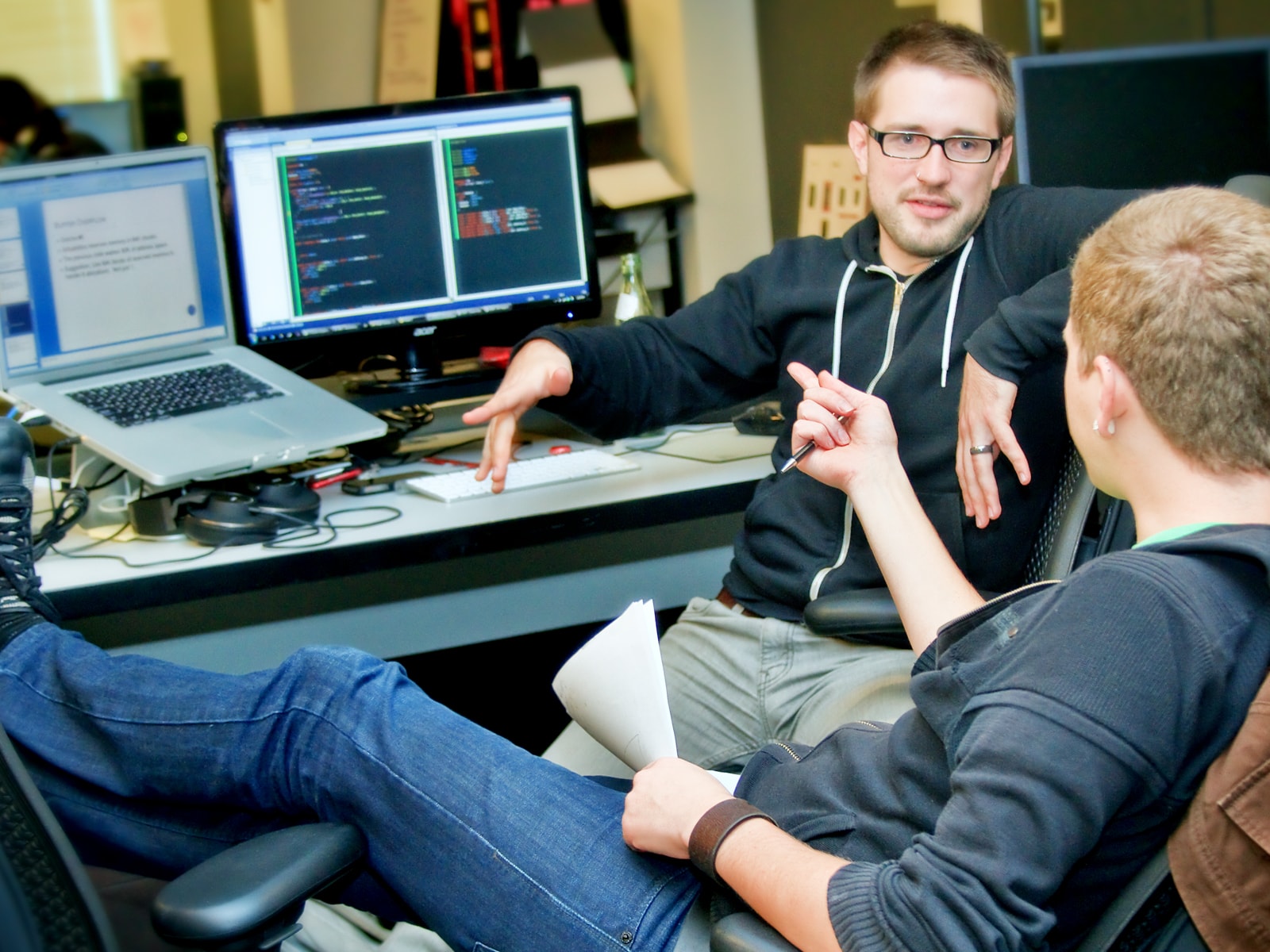 Two students chatting in their team space on the DigiPen campus