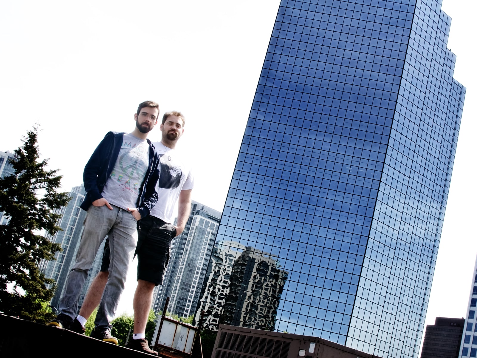 DigiPen alumni Greg Raab and Ryan Fedje standing outside the glass-walled building that houses the Camoflaj office