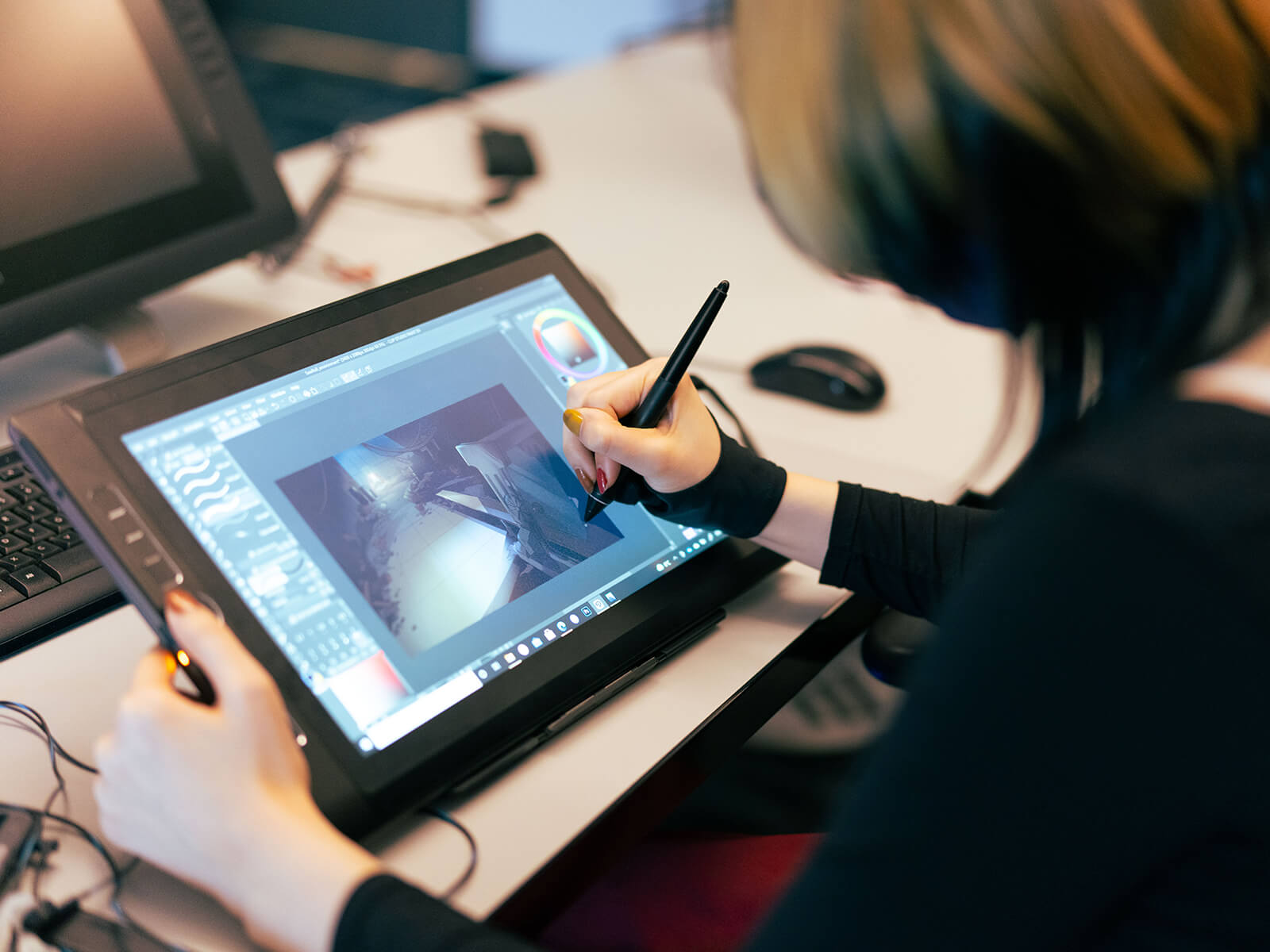 A DigiPen student works on her film team project on her drawing tablet.