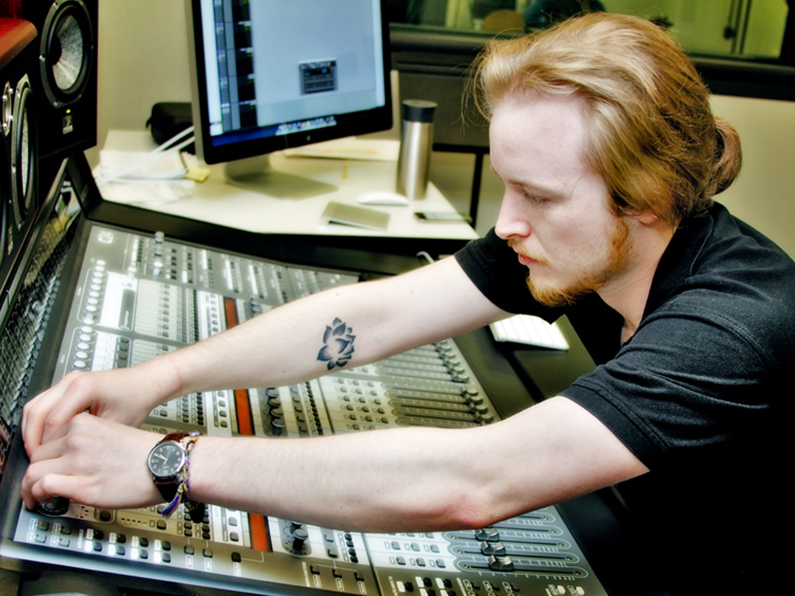 DigiPen student Ian Shores adjusting knobs on a sound board in a DigiPen recording studio