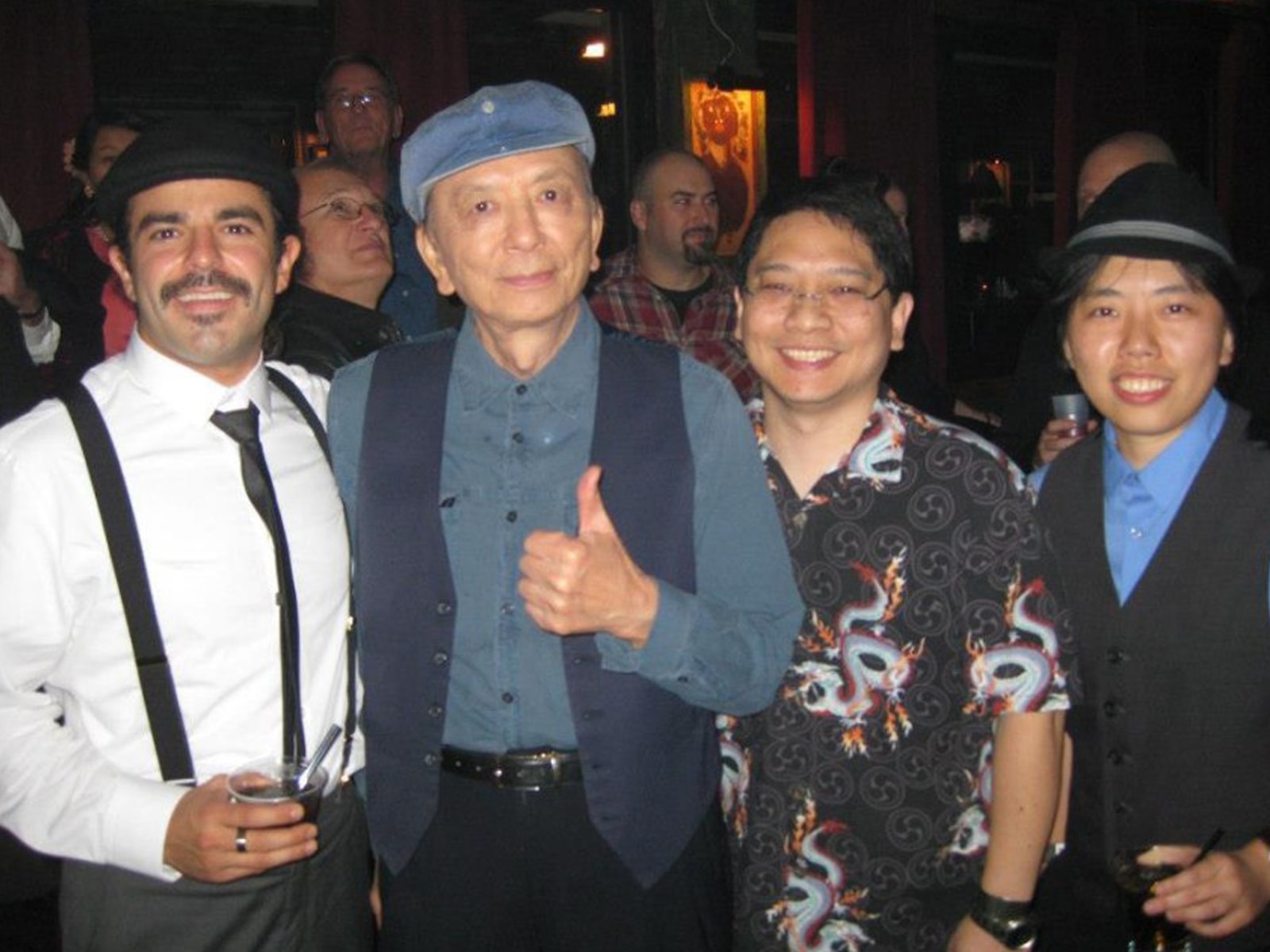 Photo of DigiPen alumna Joanna Leung and two of her colleagues with Call of Duty voice actor James Hong at a launch party 