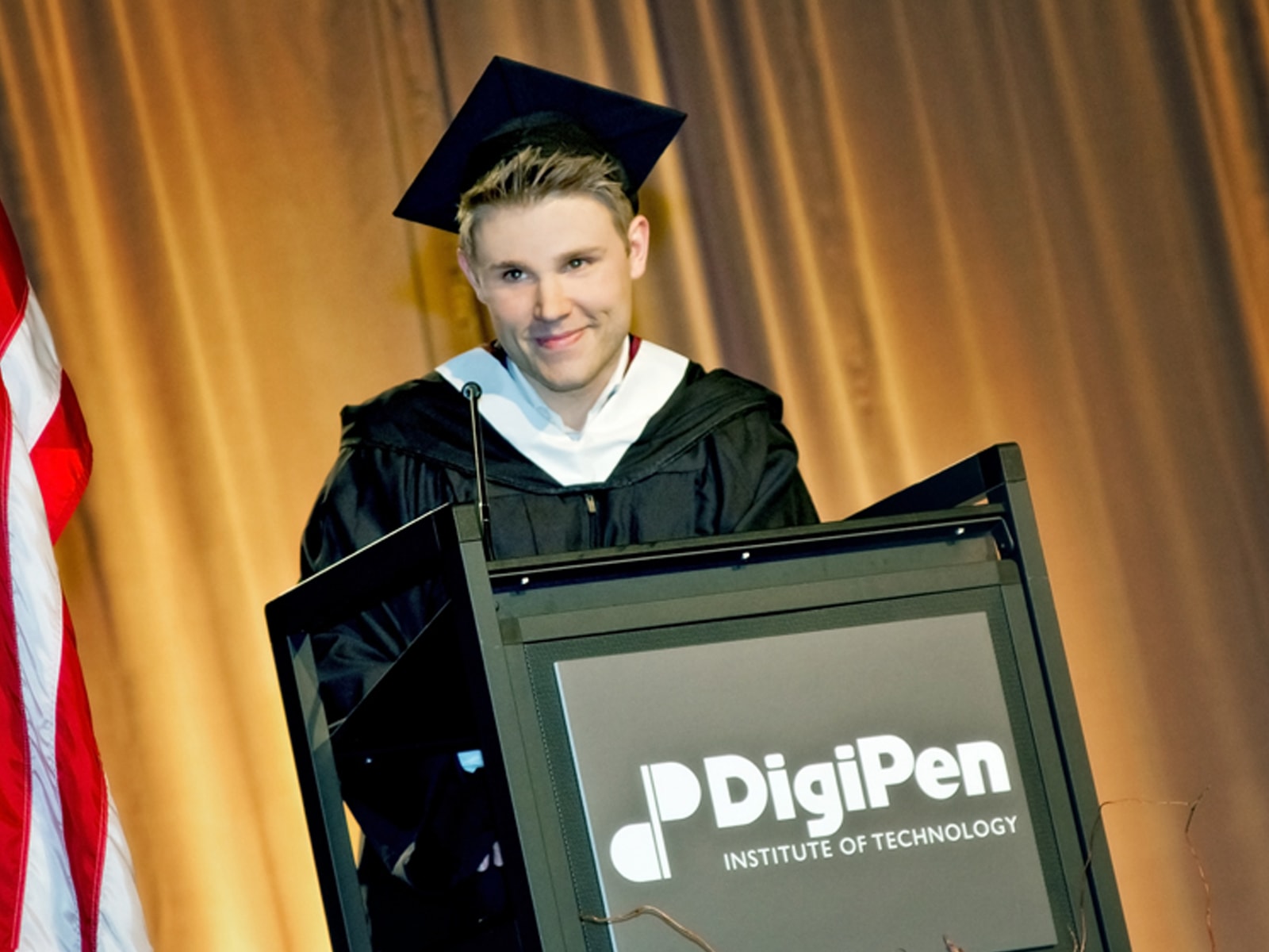 DigiPen graduate Kevin French speaking at the podium at the 2013 commencement ceremony
