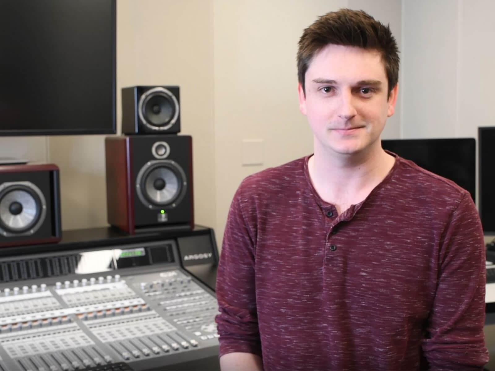 DigiPen graduate Max Hayes smiles in the campus audio lab.