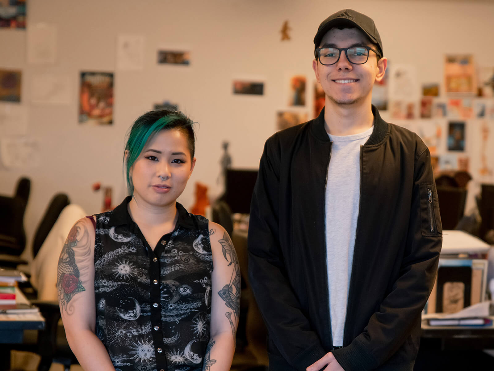 Trang “Sushie” Ta and Jesse Munguia stand next to each other in the DigiPen MFA lab.