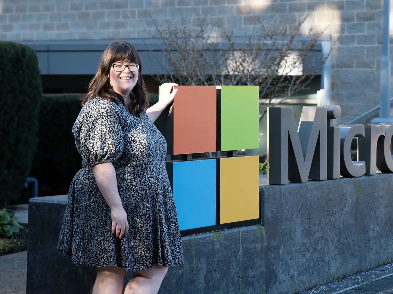 Pamela Wolf poses in front of the Microsoft logo and sign at the Redmond campus.
