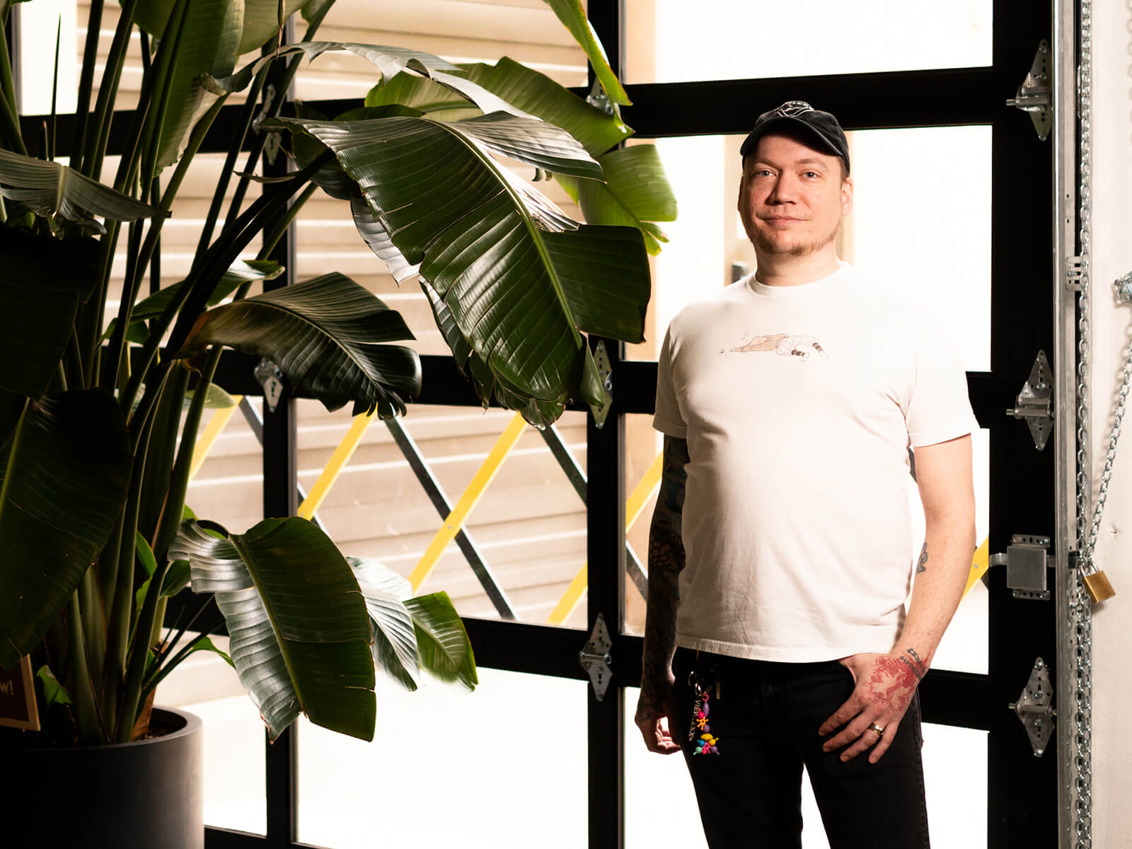 Pat Jandro poses next to a large potted plant in front of a bay door. 