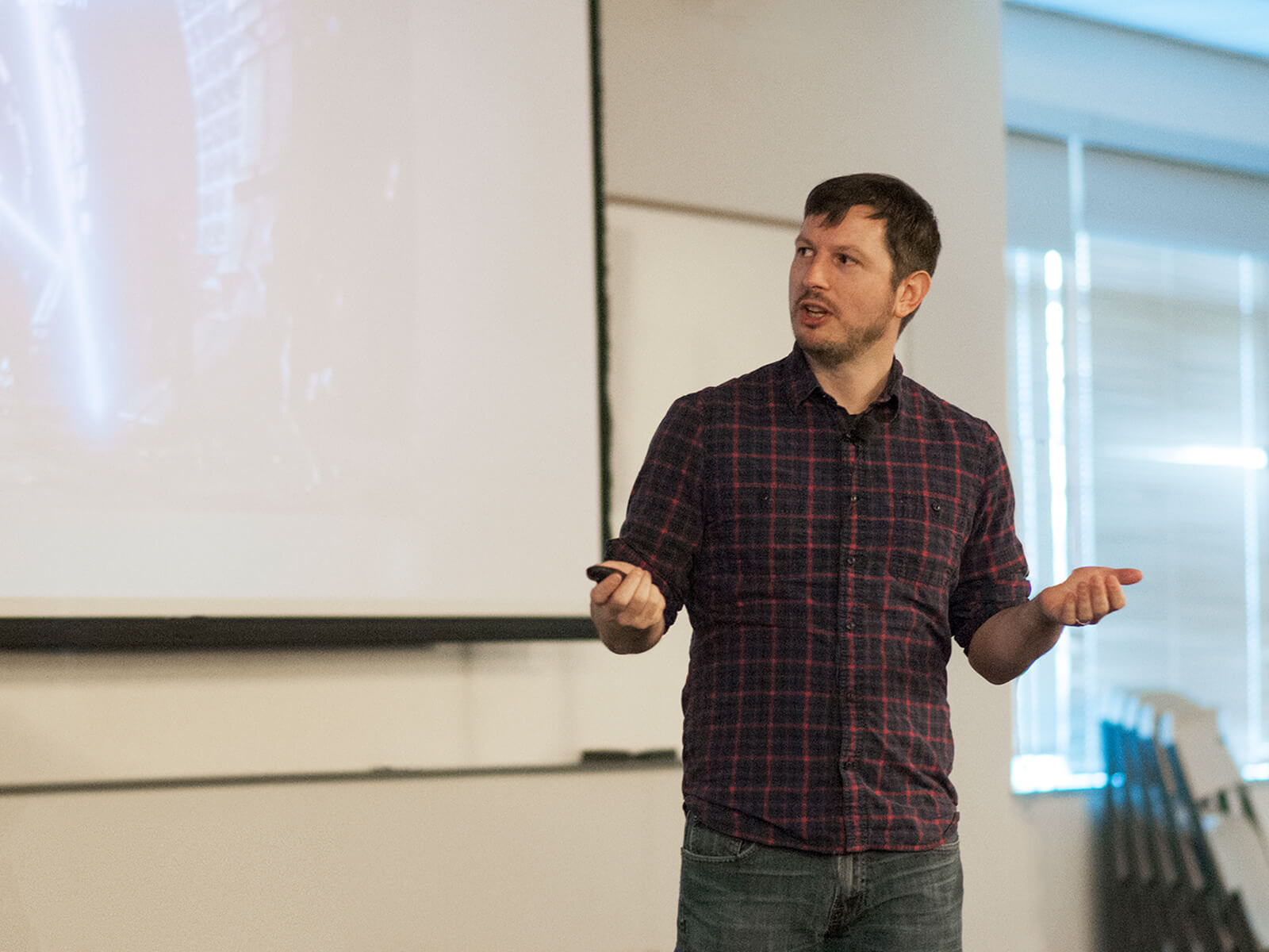 DigiPen alumnus Peter Kugler speaking in front of a projection screen at the Bungie Career Talk