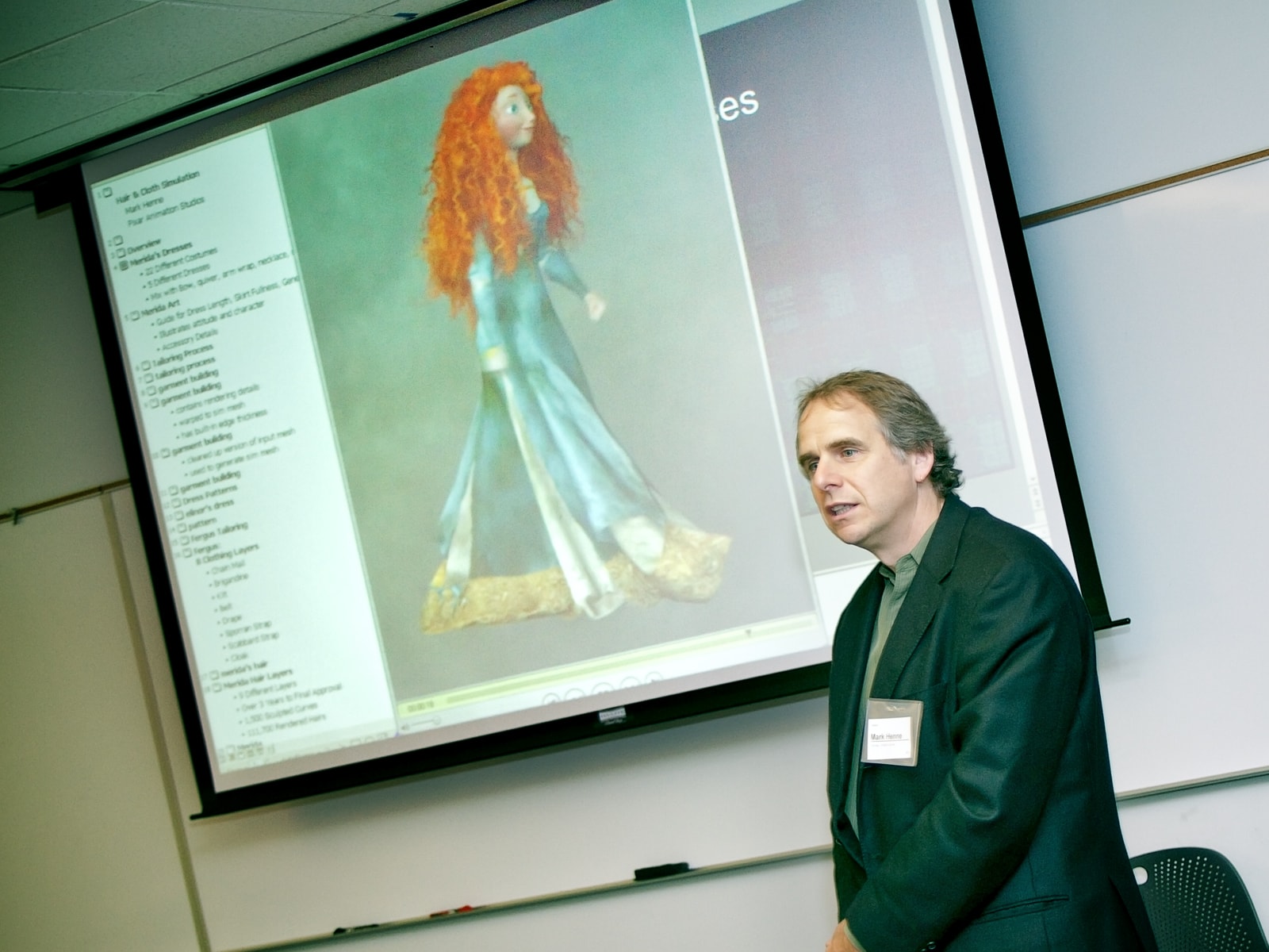 Pixar's Mark Henne speaking in front of a screen showing Princess Merida from the animated movie Brave