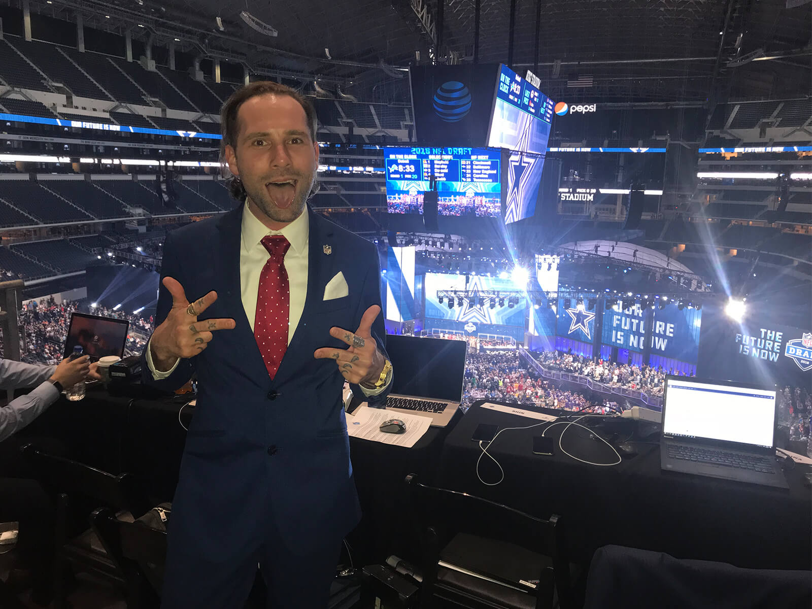 Ryan Dudley poses for the camera above the crowd at the NFL draft.