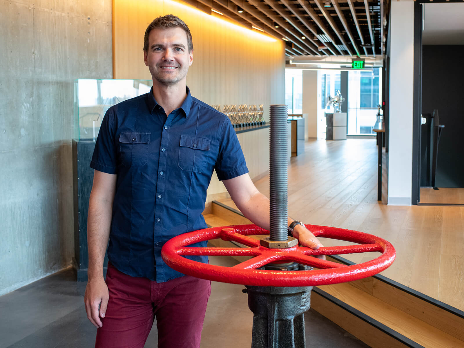 Kerry Davis stands holding the famous red steam valve at the Valve headquarters.