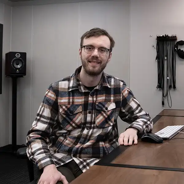 Caleb Klomparens sits at an audio workstation.