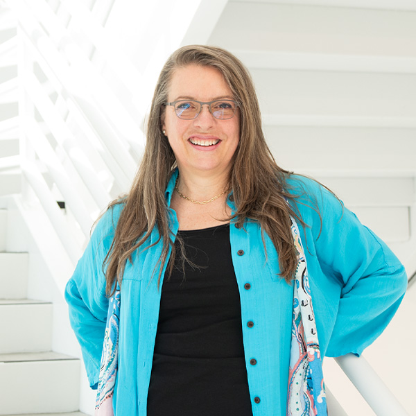 Brigitte Samson stands and smiles inside the DigiPen building.