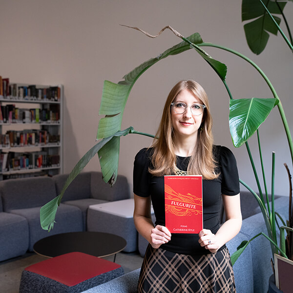 Catherine Broadwall holds up a copy of her book, Fulgurite.
