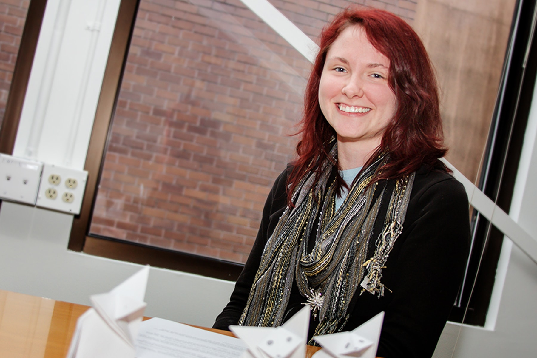 DigiPen BFA alumna Anne Feeney smiling in front of a window in the E-Line Media office