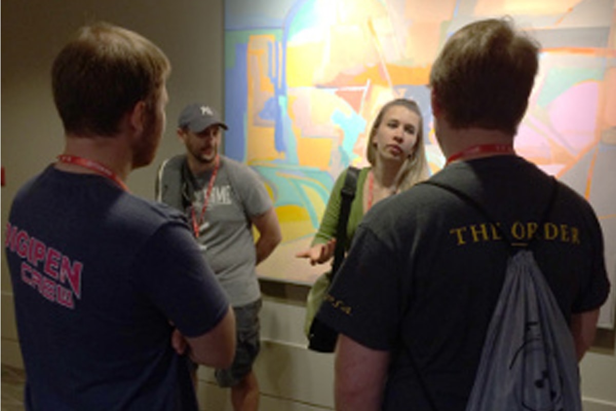 DigiPen alumna Brittany Aubert speaking with DigiPen students in a convention center hallway