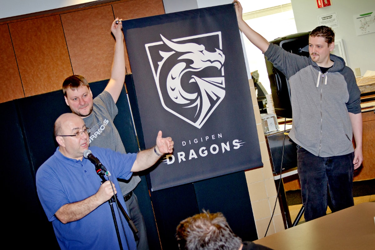 DigiPen founder and president Claude Comair unveiling the DigiPen dragon mascot during a ceremony in the DigiPen cafe